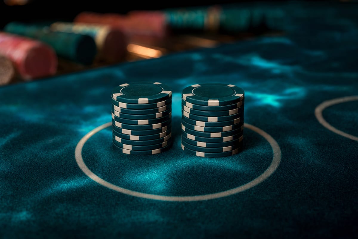 Two equal stacks of dark chips with cream edge spots standing side by side inside a betting circle on teal felt (AI-generated image)