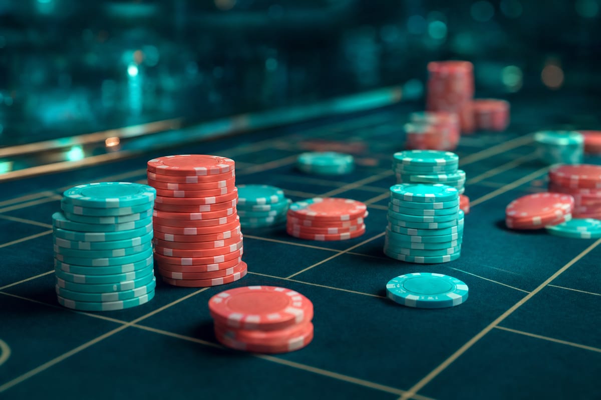 Stacks of teal and coral chips placed across the gold-lined grid of a dark green roulette betting layout (AI-generated image)