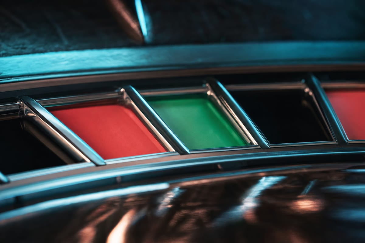 Close-up of roulette wheel pockets in a row: red, then a green pocket, then black and red, separated by chrome dividers (AI-generated image)